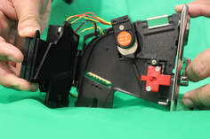 Red button on coin acceptor that needs to be pushed forward